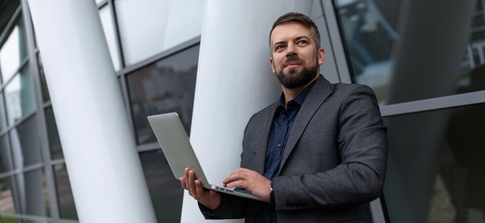 Profissional usando computador em escritório, simbolizando Internet Fibra Óptica para empresas